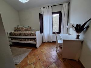 een slaapkamer met een bed, een bureau en een raam bij El Pinar de la Lobera in La Matea
