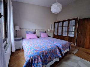 a bedroom with a large bed with pink pillows at El Pinar de la Lobera in La Matea