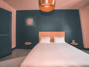 a bedroom with a large bed with a blue wall at Grand Appartement 8 personnes - parking gratuit in Mulhouse
