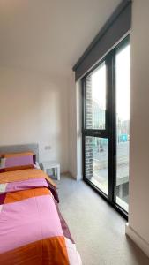a bedroom with a bed and a large window at Perfect flat next to Wembley Stadium in London