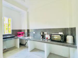a kitchen with a counter top with a microwave at Lavish Weligama in Weligama