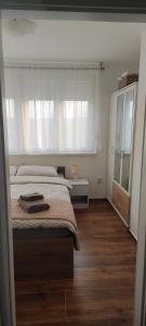 a bedroom with a large bed and a window at Apartman Klara in Osijek