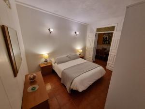 1 dormitorio con 1 cama, 1 mesa y 2 lámparas en Vivienda Vacacional Ca Na Paula en La Orotava