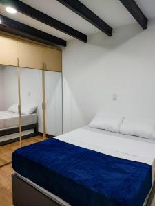 a bedroom with a large bed with a blue blanket at Casa La Riviera in Santa Rosa de Cabal