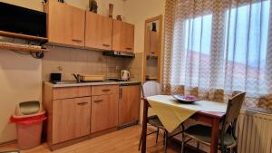 uma cozinha com uma mesa e uma pequena cozinha com uma mesa e cadeiras em Apartmani Fučkar em Krapinske Toplice