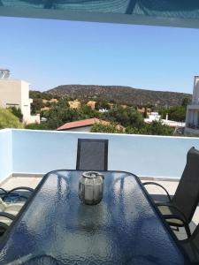 Ein Tisch und Stühle auf einem Balkon mit Aussicht in der Unterkunft Mina’s Villa, 200m from the beach in Porto Rafti