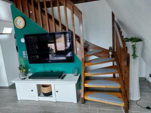 a living room with a staircase with a flat screen tv at FichtelOase in Nagel