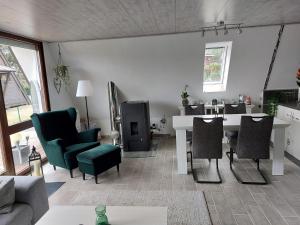 a living room with a white table and chairs at FichtelOase in Nagel