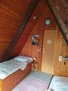 a room with two beds in a wooden cabin at Ferienhaus Angret Winkel in Meißendorf