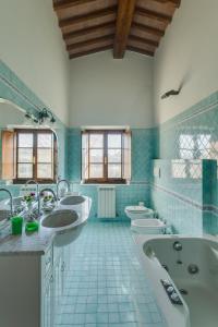 a bathroom with three sinks and a tub and toilets at Relais Antico Borgo San Lorenzo in Poggibonsi