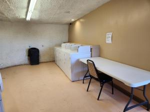 Zimmer mit einem Schreibtisch, einem Stuhl und einem Kühlschrank. in der Unterkunft Raptor Ranch in Valle