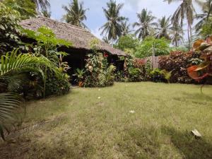 an outside view of a house with a yard at kua garden cottage in Utende