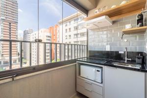 cocina con balcón con vistas a la ciudad en House of Charlie Pinheiros, en São Paulo