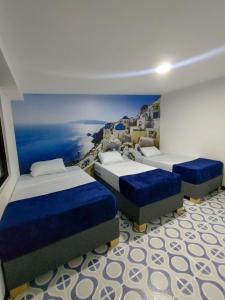 聖羅莎德卡瓦爾的住宿－Casa La Riviera，一间设有三张床的房间,并画着海洋