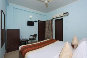 ニューデリーにあるOyo Hotel Luxury Inn Near Dhaula Kuan Delhiのベッドとデスクが備わるホテルルームです。