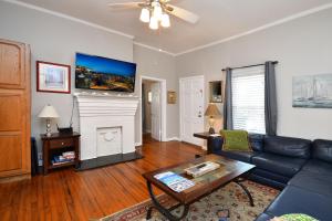 een woonkamer met een bank en een open haard bij Comfy Cottage: Minutes from Main St, Private Yard in Greenville