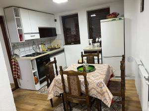una piccola cucina con tavolo e frigorifero di Mountain Vila in Ponikva a Kočani