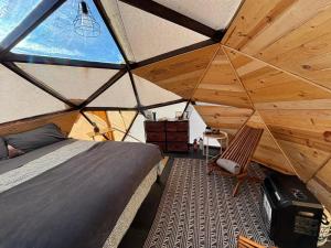 uma grande tenda com uma cama e uma cadeira em Raptor Ranch em Valle