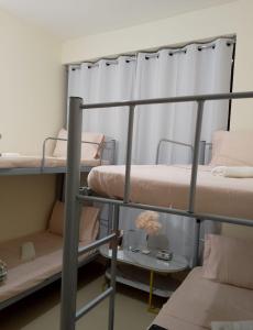 a room with three bunk beds and a table at Top House Hostel in Abu Dhabi