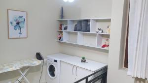 a laundry room with a washing machine and a shelf at Villa Kuci, Drobonik Berat in Berat