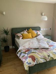 a bedroom with a bed with colorful sheets and a lamp at Springwood - Royal Hillsborough in Hillsborough