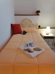 a bedroom with a large orange bed with a towel and a book at Appartamento con terrazza e giardino in Val d'Intelvi in Lanzo dʼIntelvi