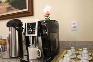 a coffee maker sitting on top of a counter at POUSADA JARDIM BOTANICO in Olímpia