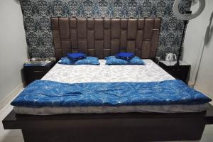a bedroom with a bed with blue pillows on it at OYO Home Abhishek Homestay in Pathānkot
