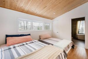 two beds in a room with two windows at Cozy and beautiful chalet in Harrington +53 photos