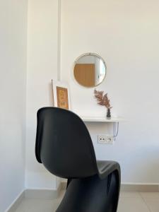 una silla negra frente a un escritorio blanco con espejo en Apartamento San Juan 3 en Murcia