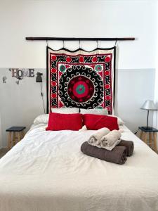 1 dormitorio con cama con almohadas rojas y manta en Apartamento San Juan 3, en Murcia
