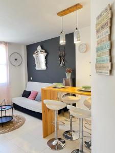 cocina y sala de estar con mesa y taburetes en Apartamento San Juan 3, en Murcia
