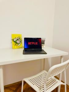 a laptop sitting on a white desk with a chair at Hostel Green World in Novi Sad