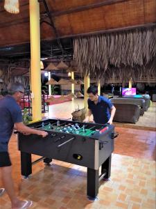 zwei Männer spielen mit einem Billardtisch in einem Zimmer in der Unterkunft Mango Home Riverside in Ben Tre