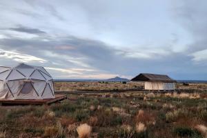 una tenda e un edificio in mezzo a un campo di Raptor Ranch a Valle