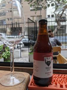 a bottle of beer sitting next to a wine glass at Hospedaje Boutique Albergue Verde in Lima