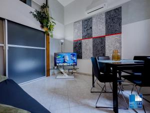 ein Wohnzimmer mit einem Tisch und einem TV in der Unterkunft [S.Orsola] Industrial Design Suite* * * * * in Bologna
