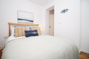 a bedroom with a bed with a white bedspread at Seaside town apartment 10 mins from Cardiff! in Cardiff