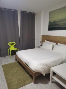 1 dormitorio con 1 cama grande y 1 silla amarilla en MILANFORESTER, en Milán