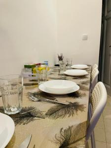 a dining room table with plates and glasses on it at Hostel Green World in Novi Sad