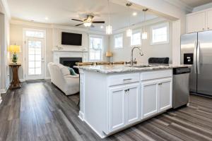 a kitchen with white cabinets and a sink and a fireplace at Three Minute walk to the Beach in Virginia Beach