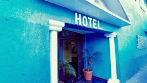 Hotel Plaza San Juan في مدينة ميكسيكو: مبنى ازرق عليه لافته الفندق