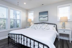 a bedroom with a white bed and two windows at Three Minute walk to the Beach in Virginia Beach