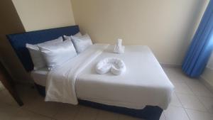 een bed met twee witte handdoeken erop bij ChabaA5SQ in Nairobi