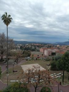 uma vista para um parque com uma palmeira e uma cidade em Le first em Grasse
