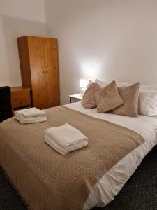 um quarto com uma cama com duas toalhas em Shortridge Terrace - 1 em Jesmond