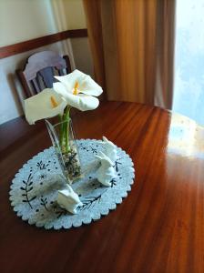 um vaso com flores brancas sobre uma mesa de madeira em Cávado Terrace Studio em Parada de Tibães