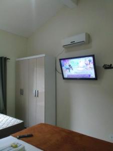 Zimmer mit einem Flachbild-TV an der Wand in der Unterkunft Hospedagem Pousada Fantasia Paraty in Paraty