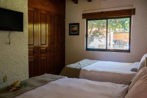 ein Hotelzimmer mit 2 Betten und einem Fenster in der Unterkunft Casa Mer, el oasis de la música y el agua in Tequisquiapan