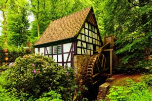 a small house and a mill in a garden at NSV-Apartments am Waldrand in Bad Essen